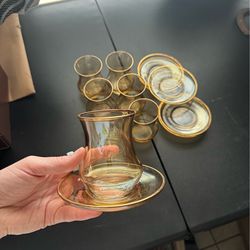 Vintage set of amber glass tumblers and stacked coasters with gold rims.
