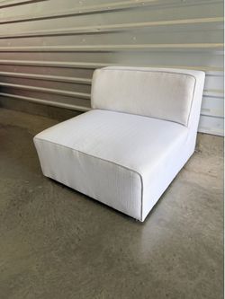 White upholstered armless chair