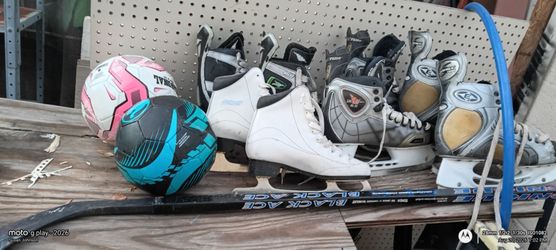 sports equipment like several paid of ice skates  a hockey stick and some balls