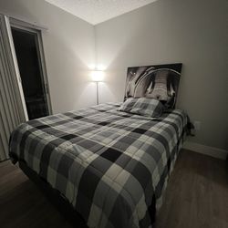 Queen size bed frame and mattress included, along with a lamp and a vintage picture