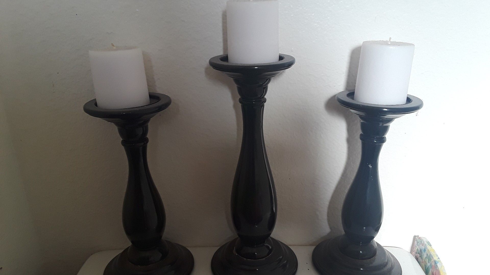 3 black pillars with white candles