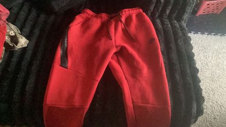 Red Nike tech pants
