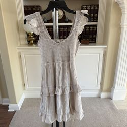 Ultra Flirt Kid's beige smocked ruffle mini dress with layered tiers and ruffle sleeve