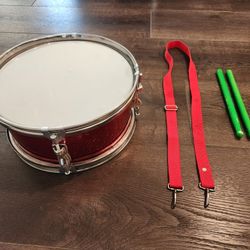 12" D 5.5" H Red Snare Drum set, complete with a strap and drumsticks. 