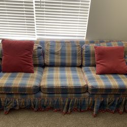 This is a traditional three-seat upholstered sofa with a classic cottage / country style design. 