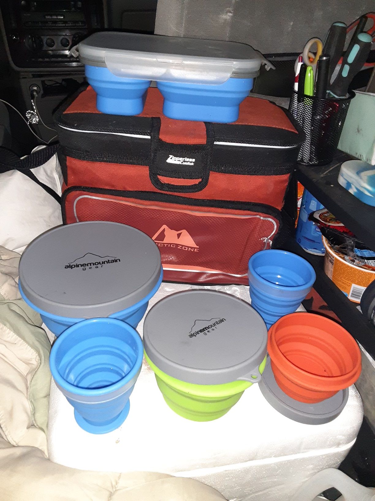 A cooler and 6 collapsible dishes. 2 cups, 3 bowls and a plate