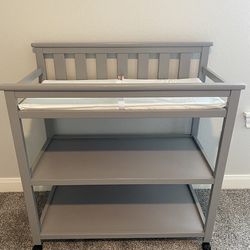 Delta Children Flat Top Changing Table with Wheels and Changing Pad -Gray