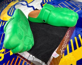 These are Bravest Studios Green Hulk Foot Clogs, featuring a molded green design with an adjustable metal buckle.
