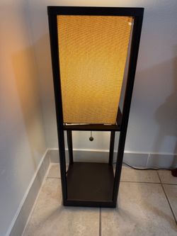 Brown floor lamp with beige fabric shade and pull chain.