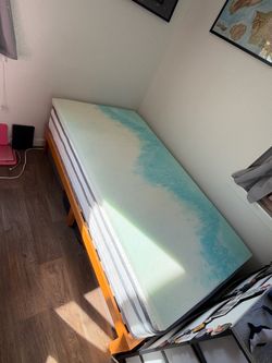 twin bed with light wooden bed frame and 2-inch foam mattress topper