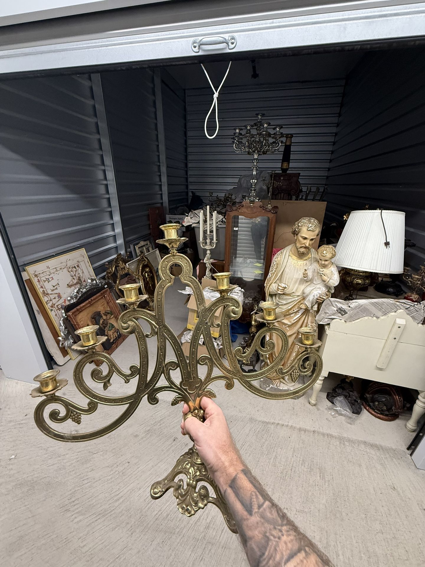 Ornate brass six-arm candelabra with scrollwork and grape motifs.