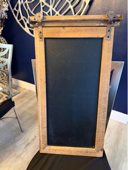 Farmhouse style wood frame chalkboard with metal decor on top