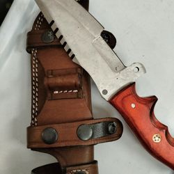 Stainless steel knife with a thick blade and leather sheath, in very good condition.