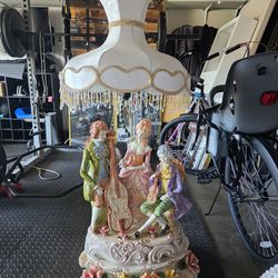 vintage table lamp is a large Italian Capodimonte porcelain piece featuring three musicians in Victorian-style attire