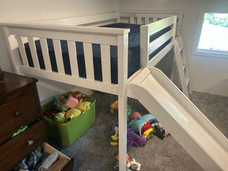 Tall bed frame with detachable slide and stairs.