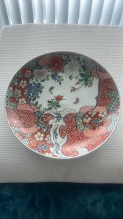 A large, antique Japanese Imari porcelain charger with floral and bird motifs.