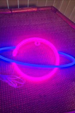 Saturn-shaped LED neon wall sign.