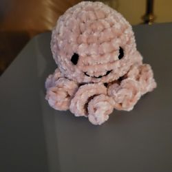 Crocheted octopus made with velvet yarn that can fit in the palm of your hand. 