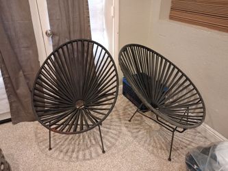 black Acapulco-style round lounge chairs