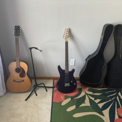 2 guitars and guitar case with a stand also 2 guitar picks