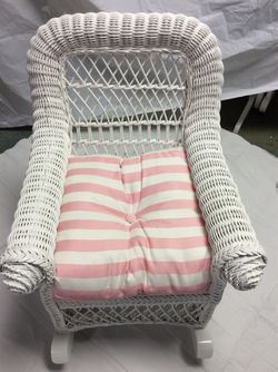 White wicker child’s rocking chair with cushion