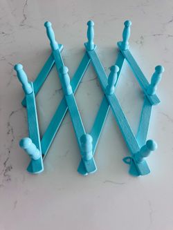 Vintage wood accordion 10 peg hat/coat rack has been painted in bright aqua blue. Sticker on back marked Nevco Japan.