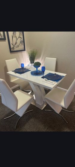 White dining room table with four chairs and two barstools