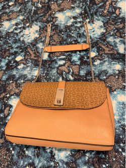 Guess monogram shoulder bag featuring a silver lock closure and chain