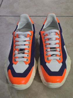 Jimmy Choo Diamond low-top sneakers in the cobalt blue and neon orange colorway, featuring a distinctive chunky faceted diamond-shaped rubber sole.