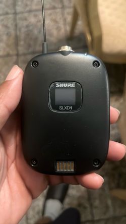 This is a Shure SLXD1 wireless bodypack transmitter featuring a prominent LCD screen.