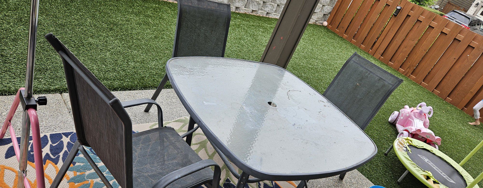Outdoor patio set with glass table and umbrella stand. 4 flex stack chairs
