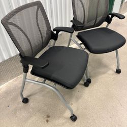 Two Global Roma Nester mesh back chairs- featuring a flip-up seat and silver casters.  These are made to hold extra weight. They are heavy duty chairs