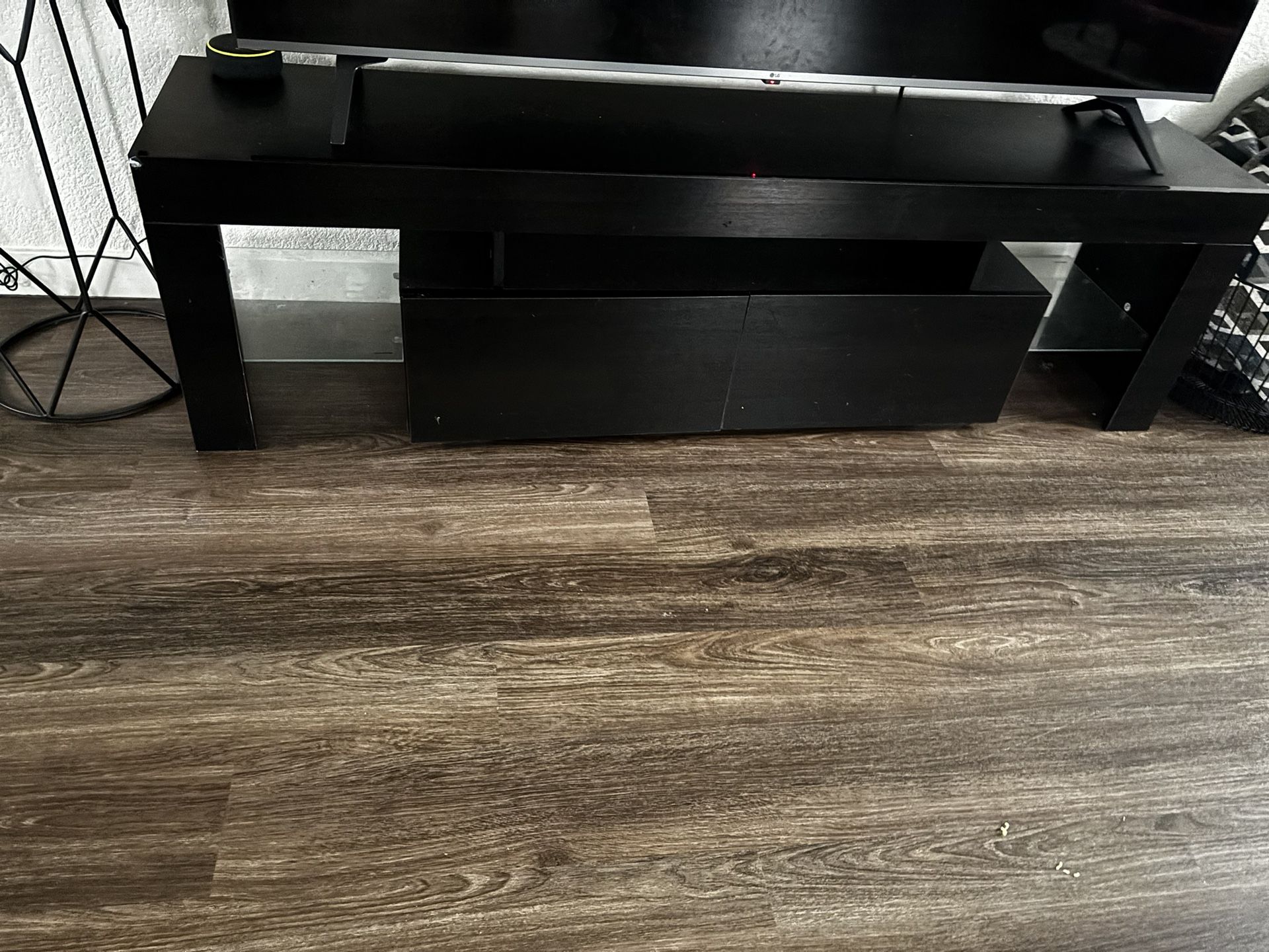 Sleek black entertainment TV stand with two storage drawers and open shelves.
