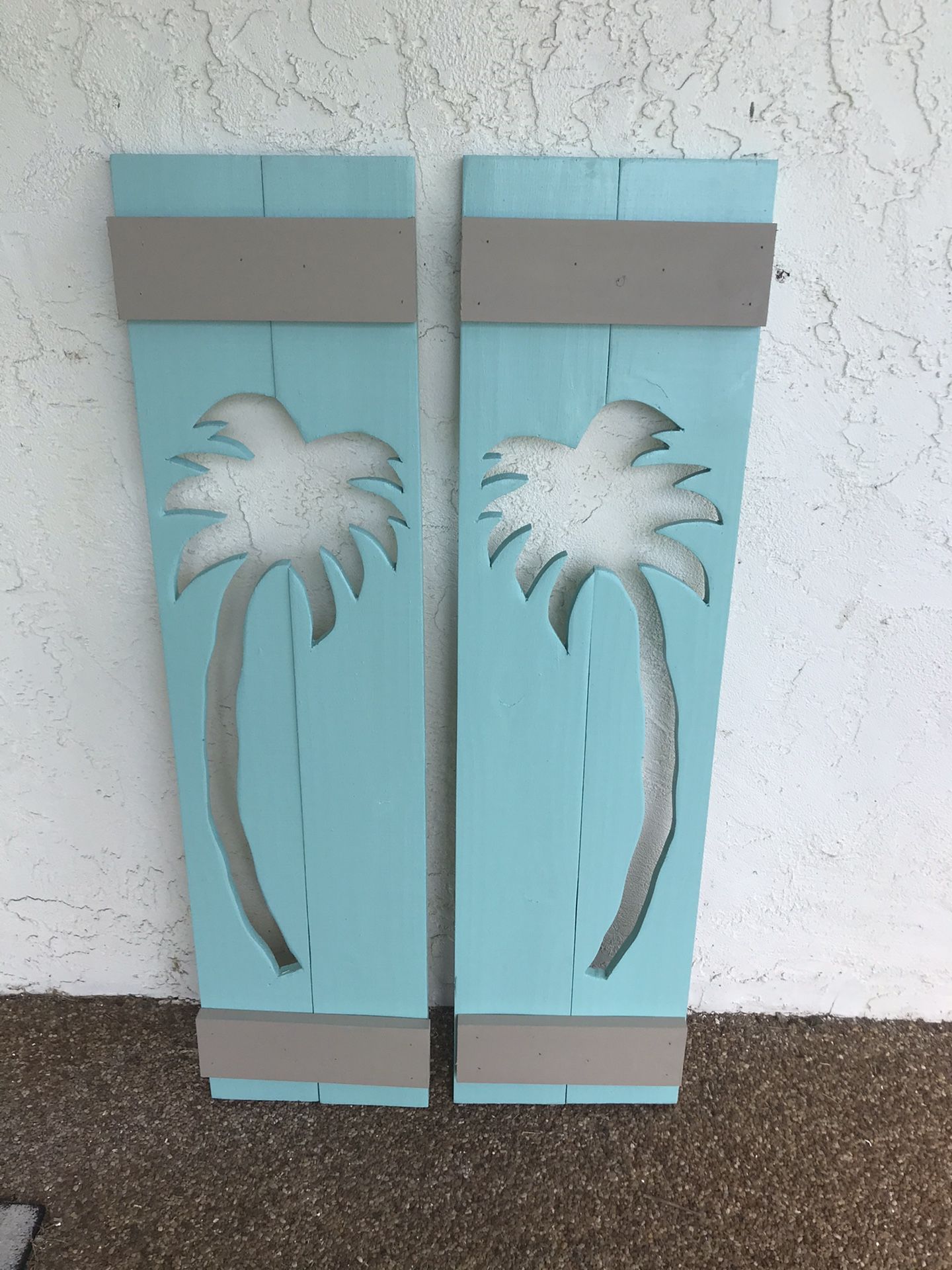 Solid wood exterior window shutters with palm tree cut outs