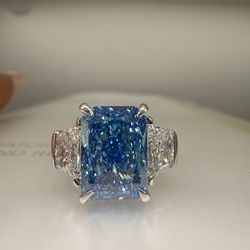 4.09 carat fancy vivid blue radiant cut diamond trapezoid three stone engagement ring
