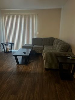 Grey Sectional couch with black tables