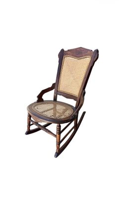 Antique rocking chair featuring a dark wood frame, a woven cane back, and a cane seat in excellent condition