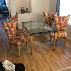 Glass dining room table and four chairs.
