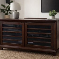 Crate & Barrel dark wood media console cabinet with glass door.