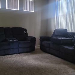 Dark-colored, two-seater reclining loveseat.
