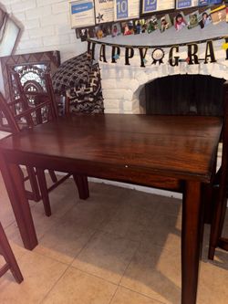 Dining table: seats 6 people, 4 singular chairs, one double seater.