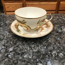 Cup & Saucer Set.  Preowned Excellent Condition No Cracks Or Chips .  Size saucer 5 inches wide and cup 2 1/2 inches by 2 1/2 inches.  Has been on dis