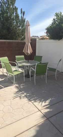 Umbrella patio table with glass and 6 chair. Umbrella weight base included