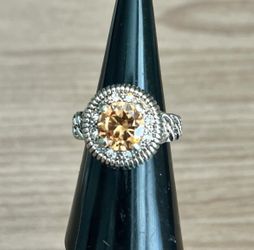 This stunning ring features a vibrant orange gemstone set in a gold-toned band. Perfect for adding a touch of elegance to any outfit.