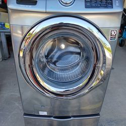 Gray stainless Samsung front load washer machine with pedestal