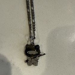 Sanrio Hello Kitty silver chain holding an AK47