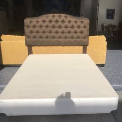 Queen size headboard and box spring and metal frame with wheels on the bottom