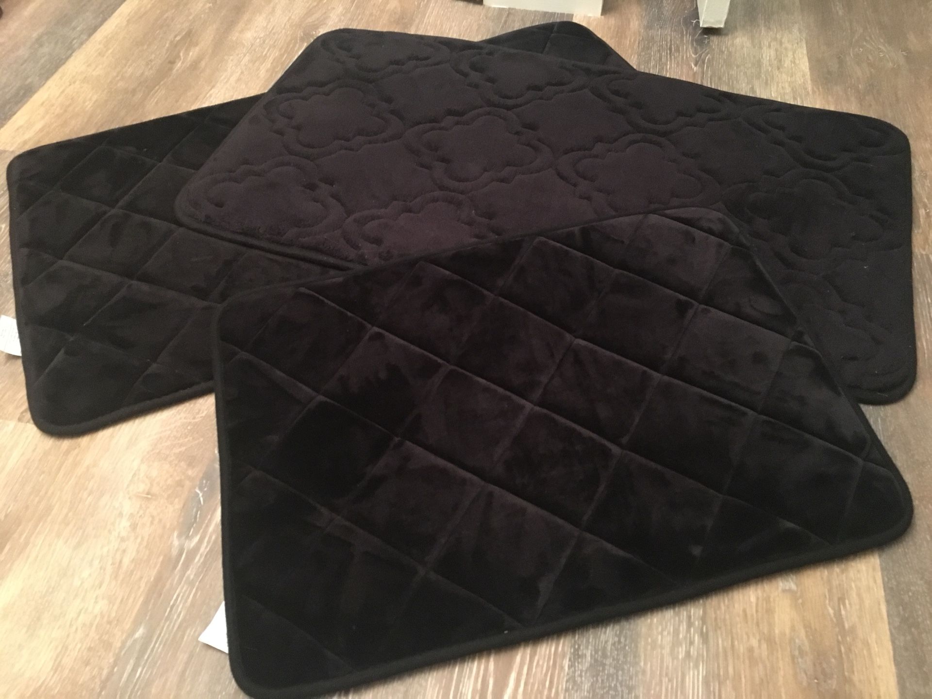 Three black padded kitchen or bath mats
