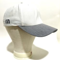 TravisMathew performance cap. The logo featured on the side panel is the brand's iconic "TM" emblem. 