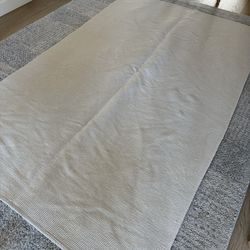Woven, washable, dryable cream color rug.  104” x 66”